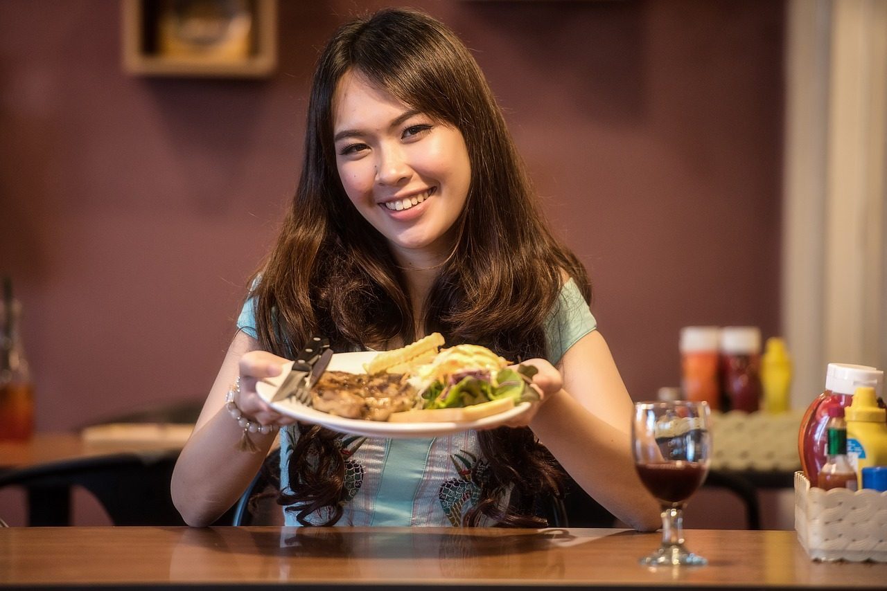 woman holding food dish in a restaurant