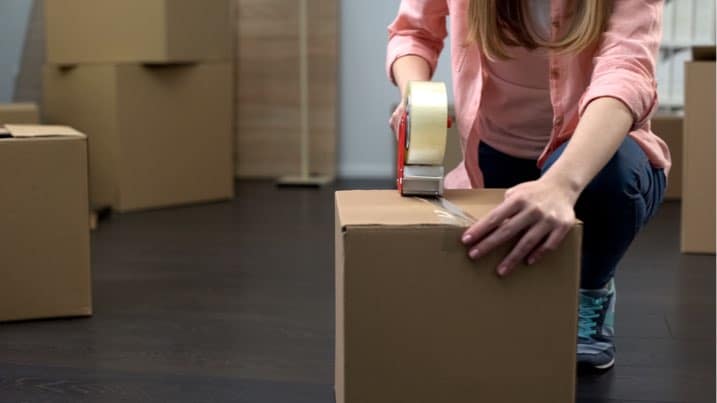 woman taping moving boxes